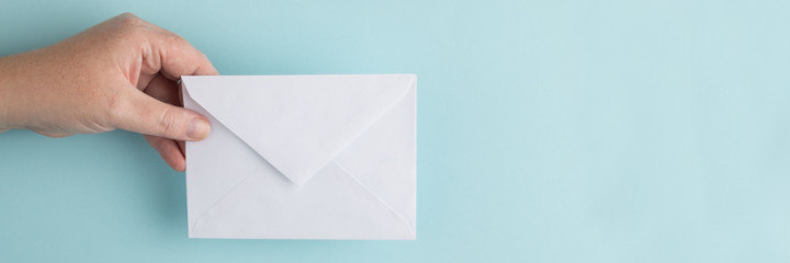 Person holding white envelope